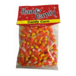 A clear plastic bag labeled Handy Candy CANDY CORN contains orange, yellow, and white candy corn pieces. The package has a net weight of 5.5 oz (155 g).