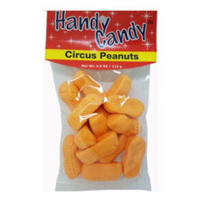 A clear bag labeled Handy Candy CIRCUS PEANUTS holds orange, peanut-shaped marshmallow candies. Red packaging with white stars and text. Net weight: 4.0 oz (113 g).